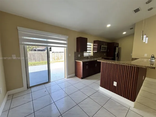 a kitchen with stainless steel appliances granite countertop a refrigerator and a sink