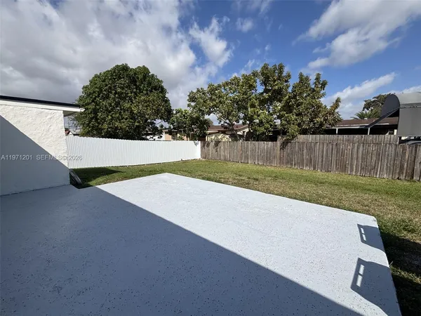 a view of a yard with wooden fence