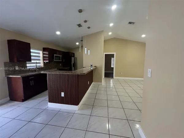 a kitchen with stainless steel appliances a sink a counter top space cabinets and a window