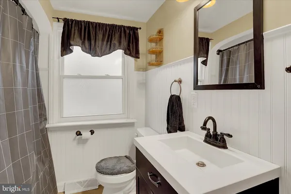 a bathroom with a sink mirror and toilet