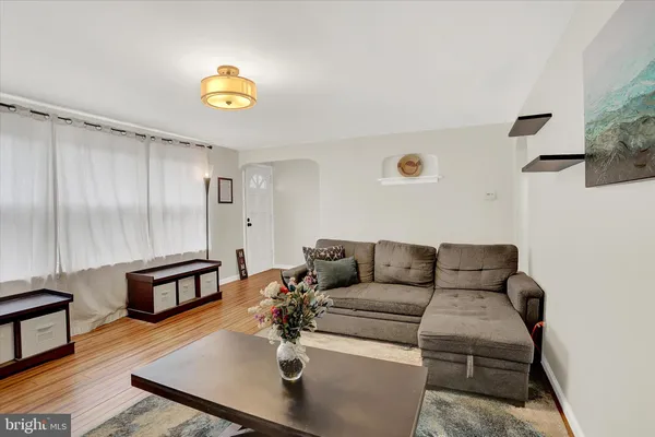 a living room with furniture and a wooden floor