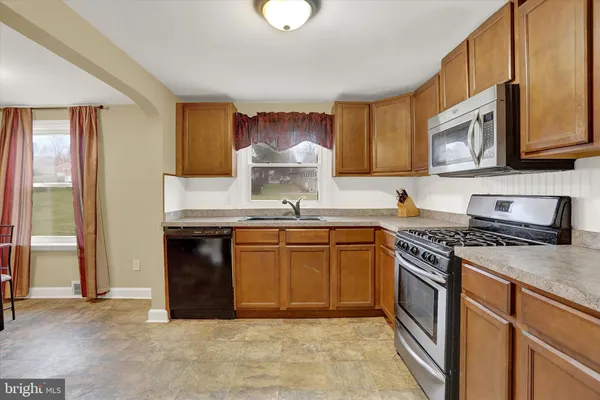 a kitchen with stainless steel appliances granite countertop a stove sink and cabinets
