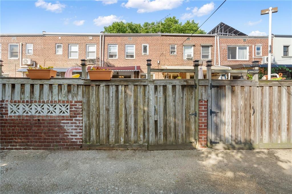 2472 Stuart Street Brooklyn, NY 11229 - Photo 28 of 28 a view of a house with a floor to ceiling window and a tree