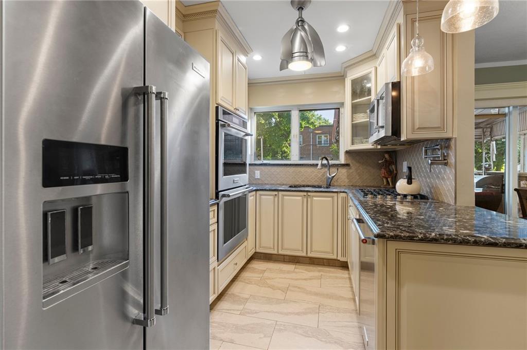 2472 Stuart Street Brooklyn, NY 11229 - Photo 9 of 28 a kitchen with a sink a counter top space cabinets stainless steel appliances and a window