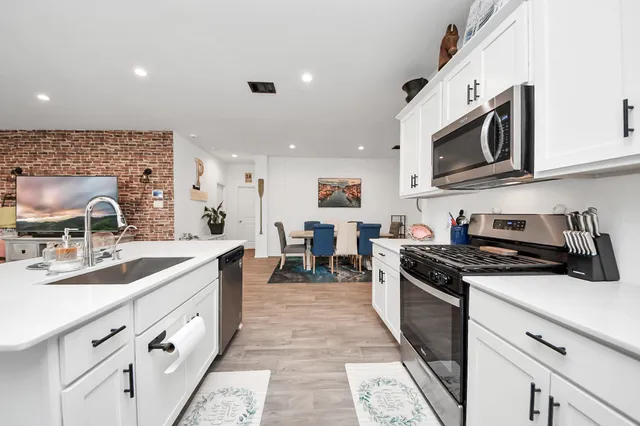 a kitchen with stainless steel appliances granite countertop a sink and stove top oven