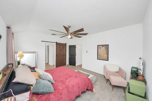 a bedroom with a bed couch and window