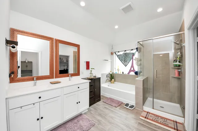 a bathroom with a double vanity sink mirror and shower
