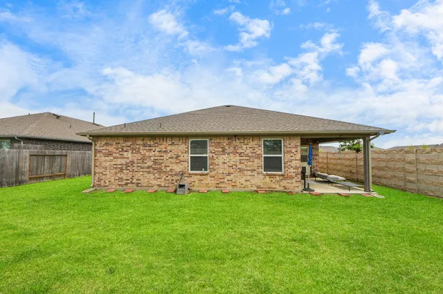 a view of a house with a yard and sitting area