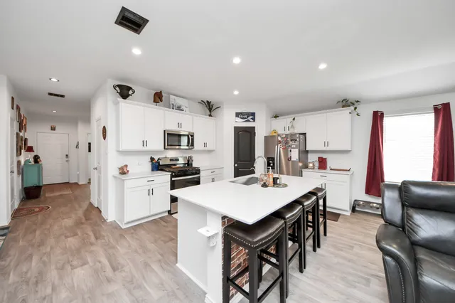 a large kitchen with cabinets table and chairs