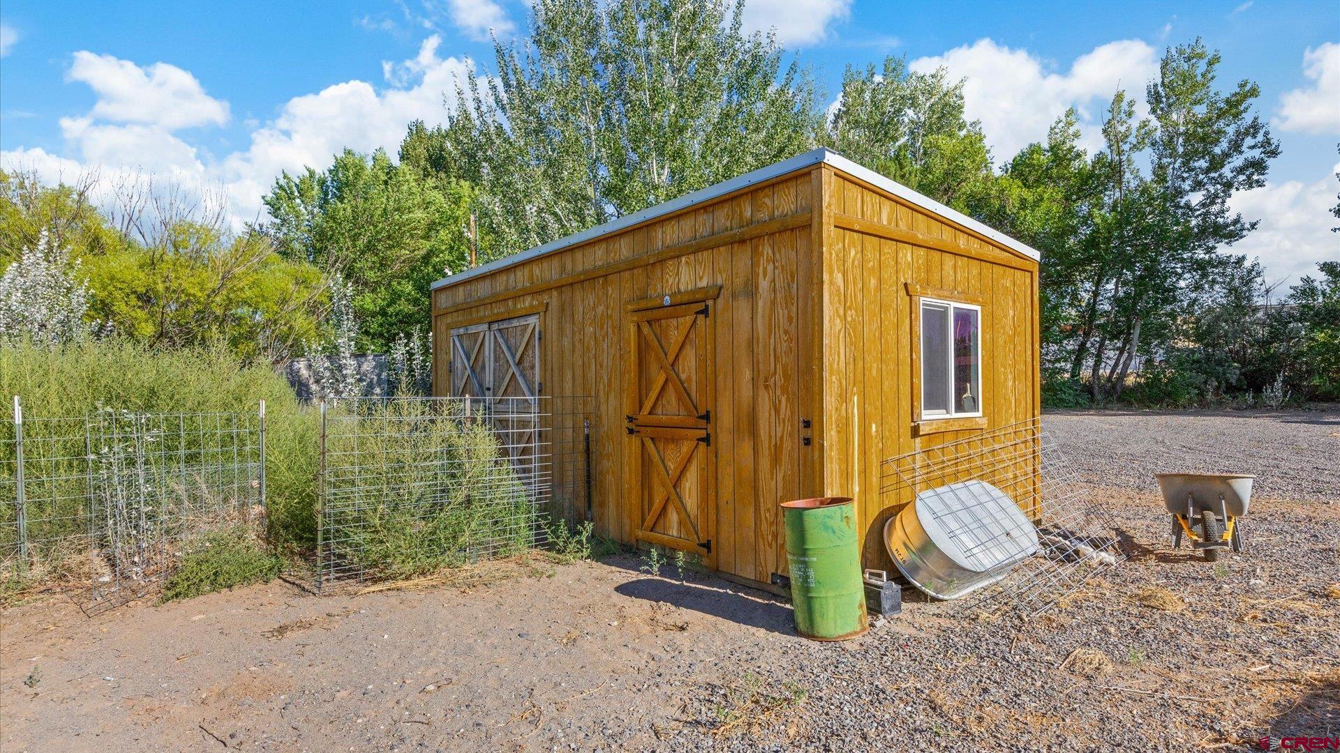 21017 Austin Road Austin, CO 81410 - Photo 25 of 29 a view of a wooden house with large trees and wooden fence