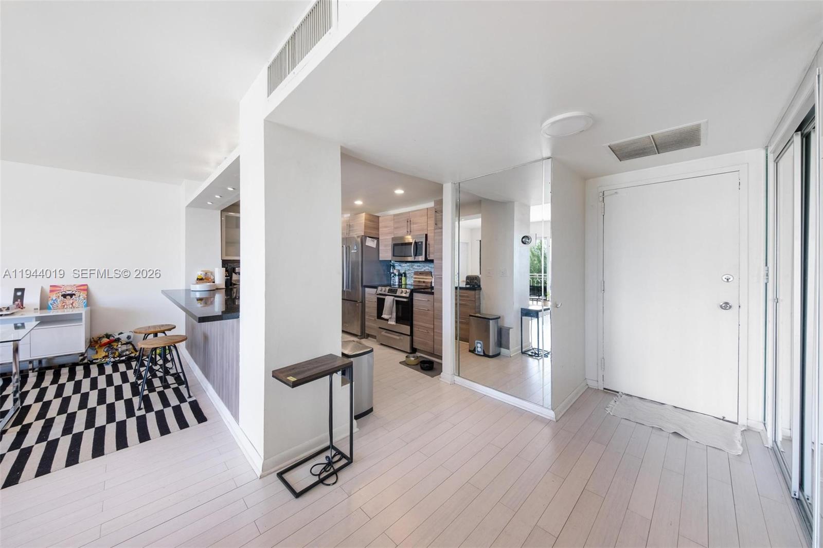 11111 Biscayne Boulevard, Unit 2D Miami, FL 33181 - Photo 8 of 26 a bedroom with a bed and wooden floor