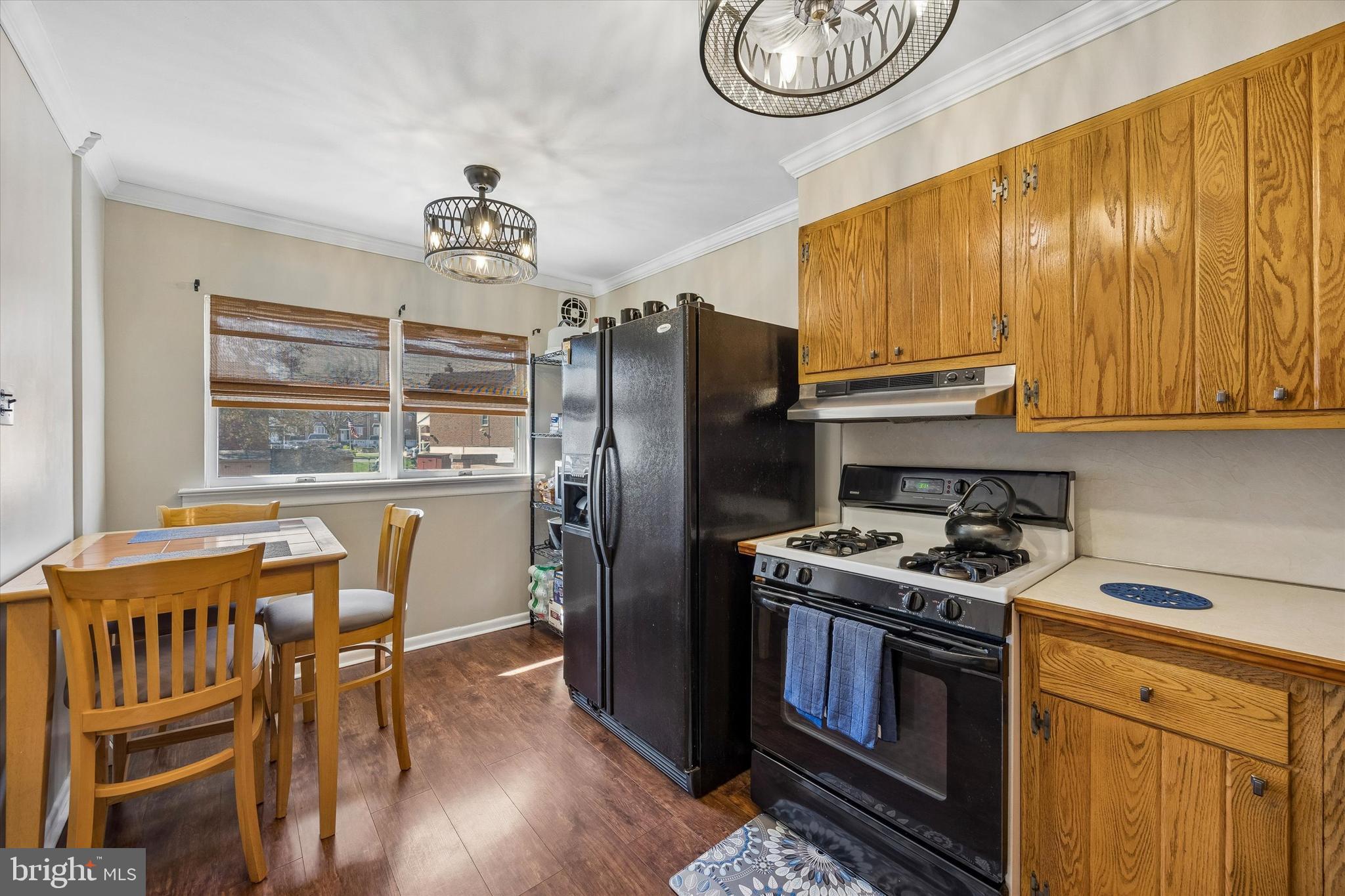 3212 Atmore Road Philadelphia, PA 19154 - Photo 12 of 25 a kitchen with stainless steel appliances granite countertop a stove a refrigerator a sink dishwasher a dining table and chairs with wooden floor