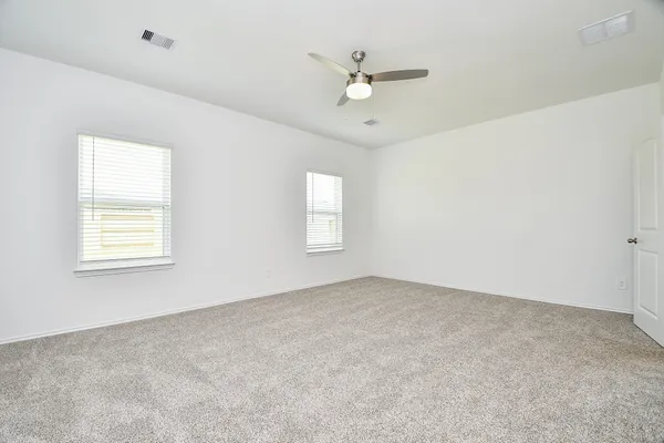 an empty room with windows and fan