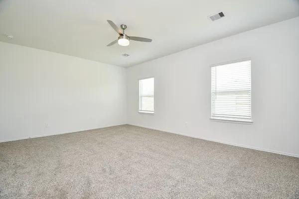 an empty room with a window and a fan