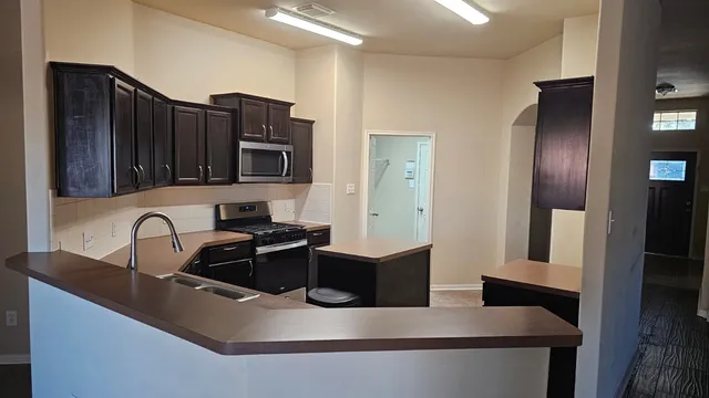 a kitchen with granite countertop a refrigerator and a sink