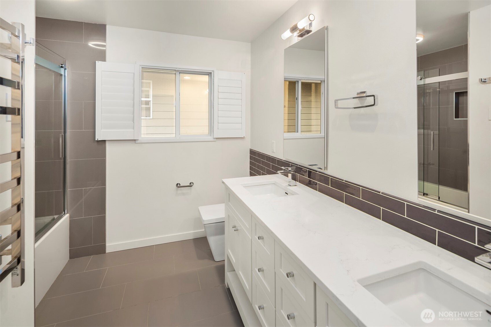 5819 Northeast 1st Street Renton, WA 98059 - Photo 33 of 38 a bathroom with a double vanity sink a mirror and a bathtub