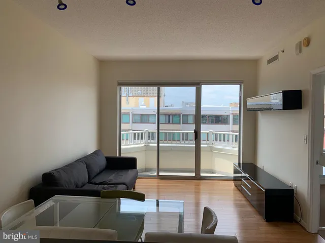 a living room with furniture and a floor to ceiling window