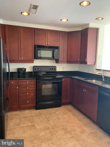 a kitchen with granite countertop a stove top oven sink and cabinets