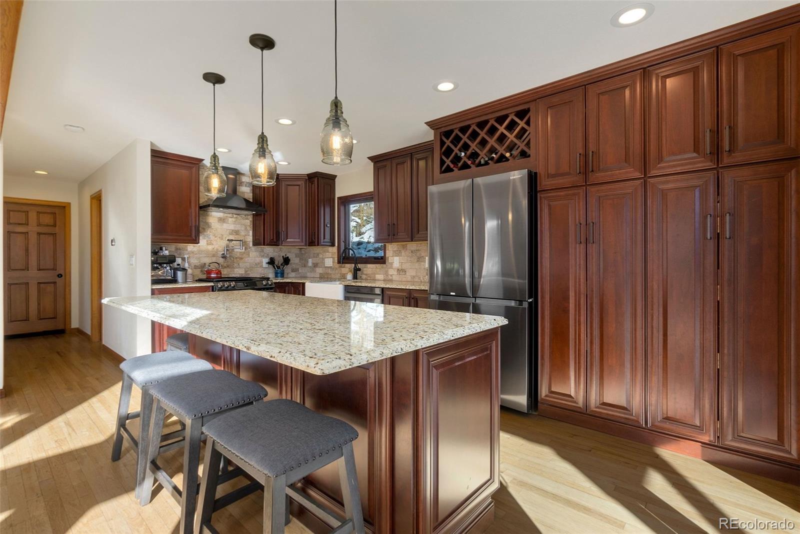 33773 Elk Run Evergreen, CO 80439 - Photo 11 of 35 a kitchen with stainless steel appliances granite countertop a table chairs and a refrigerator