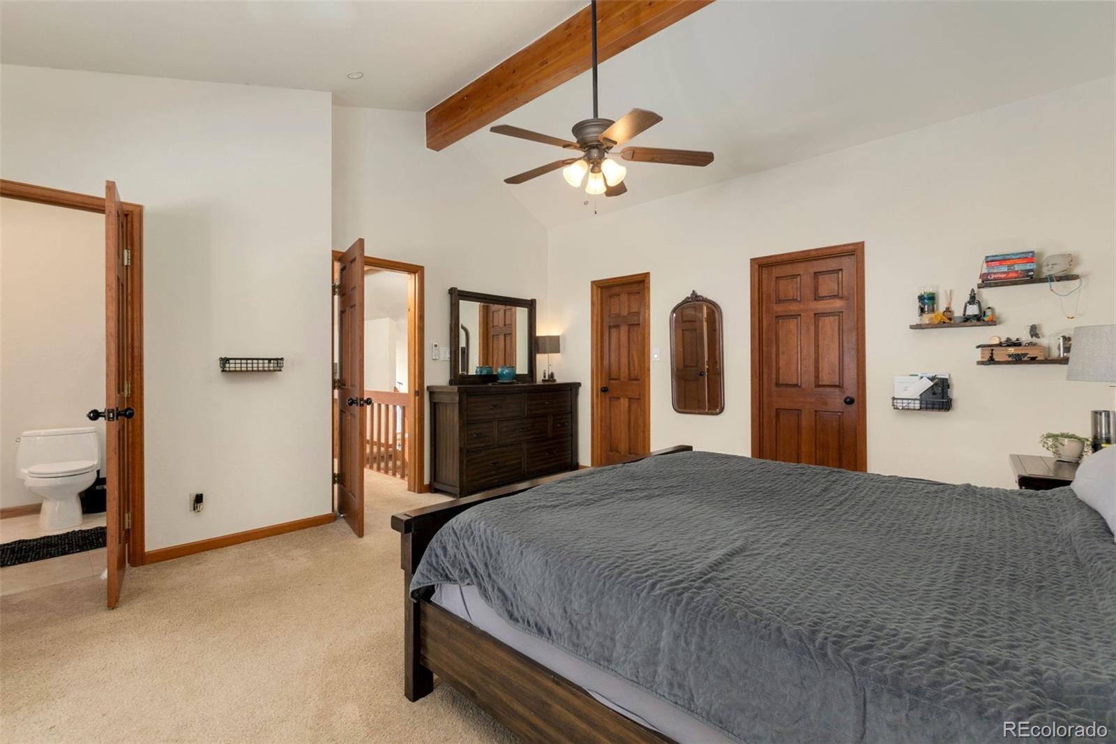 33773 Elk Run Evergreen, CO 80439 - Photo 16 of 35 a spacious bedroom with a bed and a chandelier