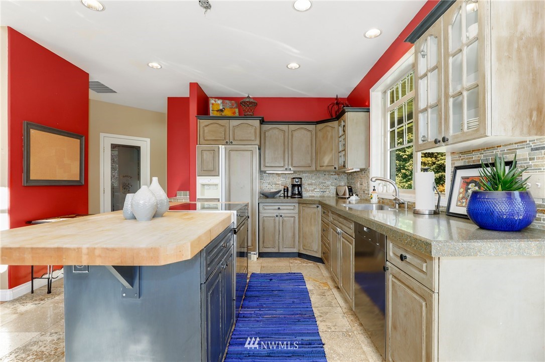 18318 Butler Road Snohomish, WA 98290 - Photo 6 of 25 a kitchen with stainless steel appliances granite countertop a sink and dishwasher a stove top oven with wooden floor