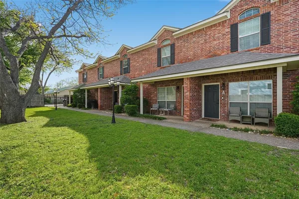 front view of a brick house with a yard