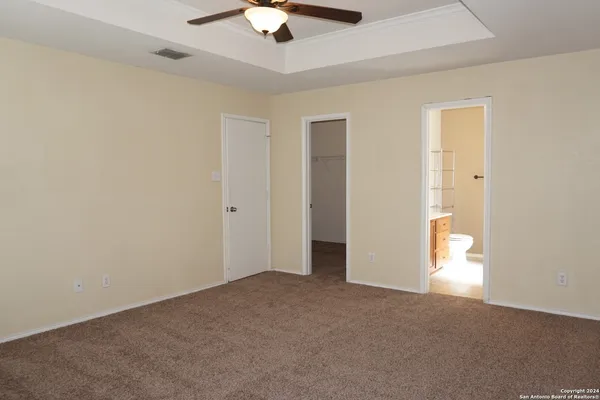 an empty room with a ceiling fan and a window