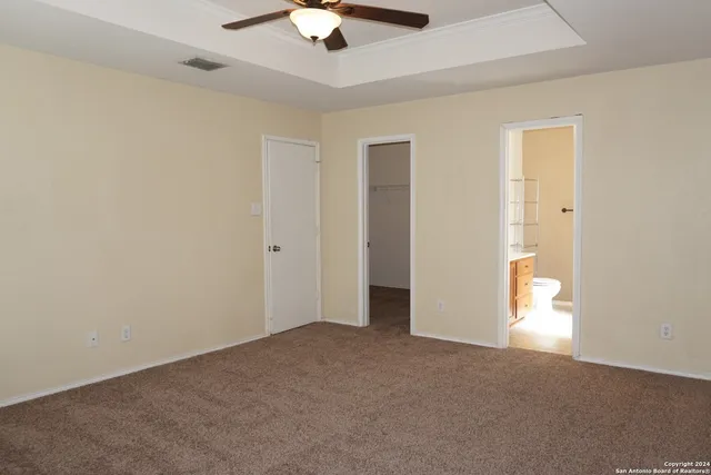 an empty room with a ceiling fan and a window