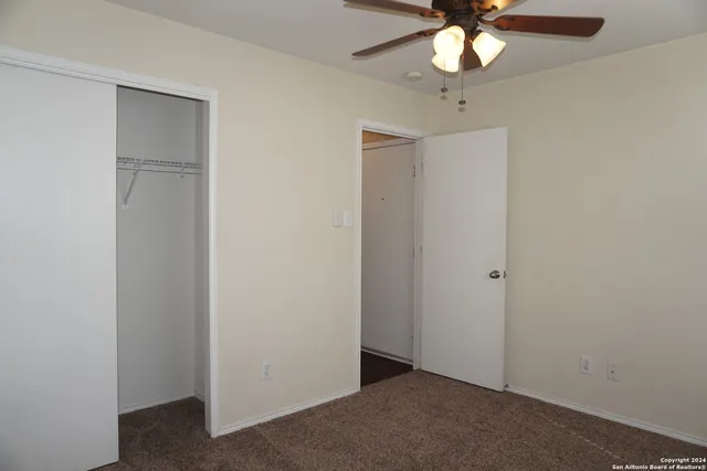 an empty room with a ceiling fan and a fan