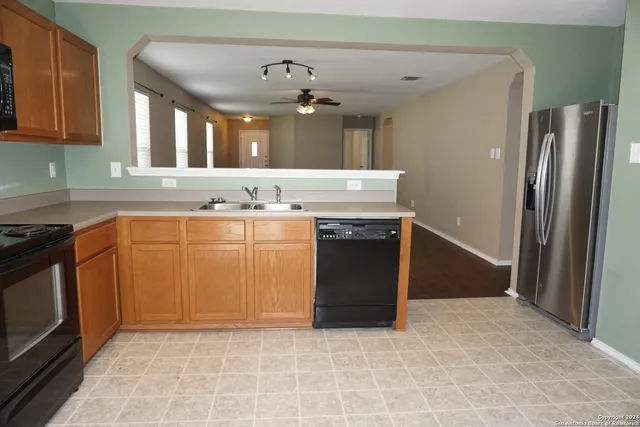 a kitchen with stainless steel appliances granite countertop a stove a sink and a refrigerator