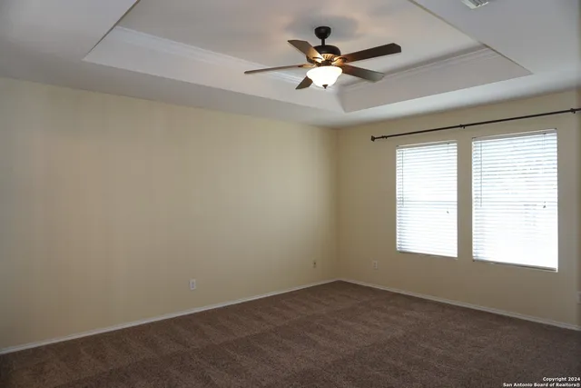 an empty room with a window and a fan