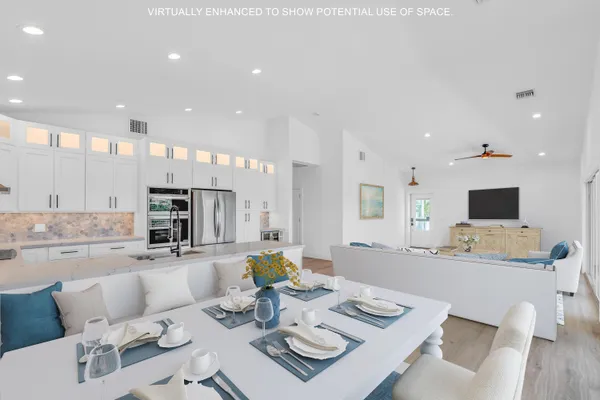 a living room with furniture kitchen view and a flat screen tv