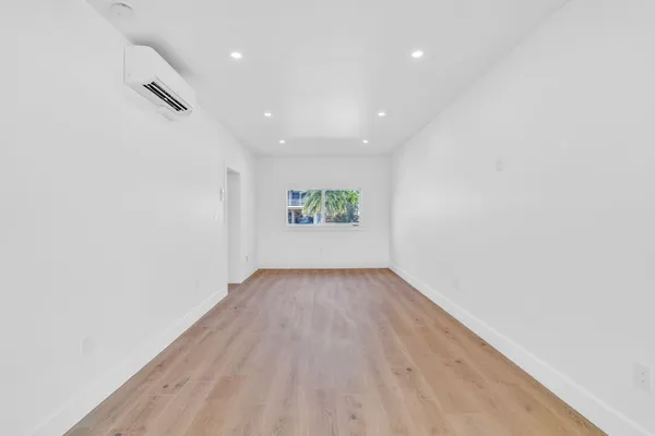 an aerial view of residential houses with outdoor space and trees