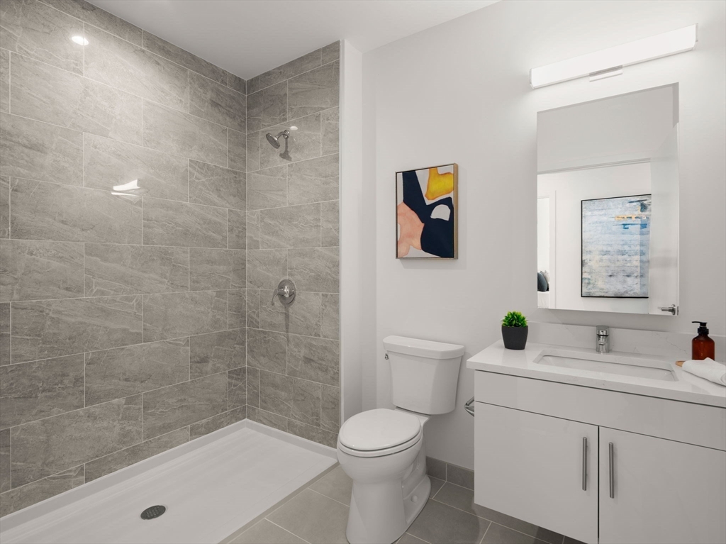 1151 Walnut Street, Unit 307 Newton, MA 02461 - Photo 11 of 32 a bathroom with a sink a toilet and shower