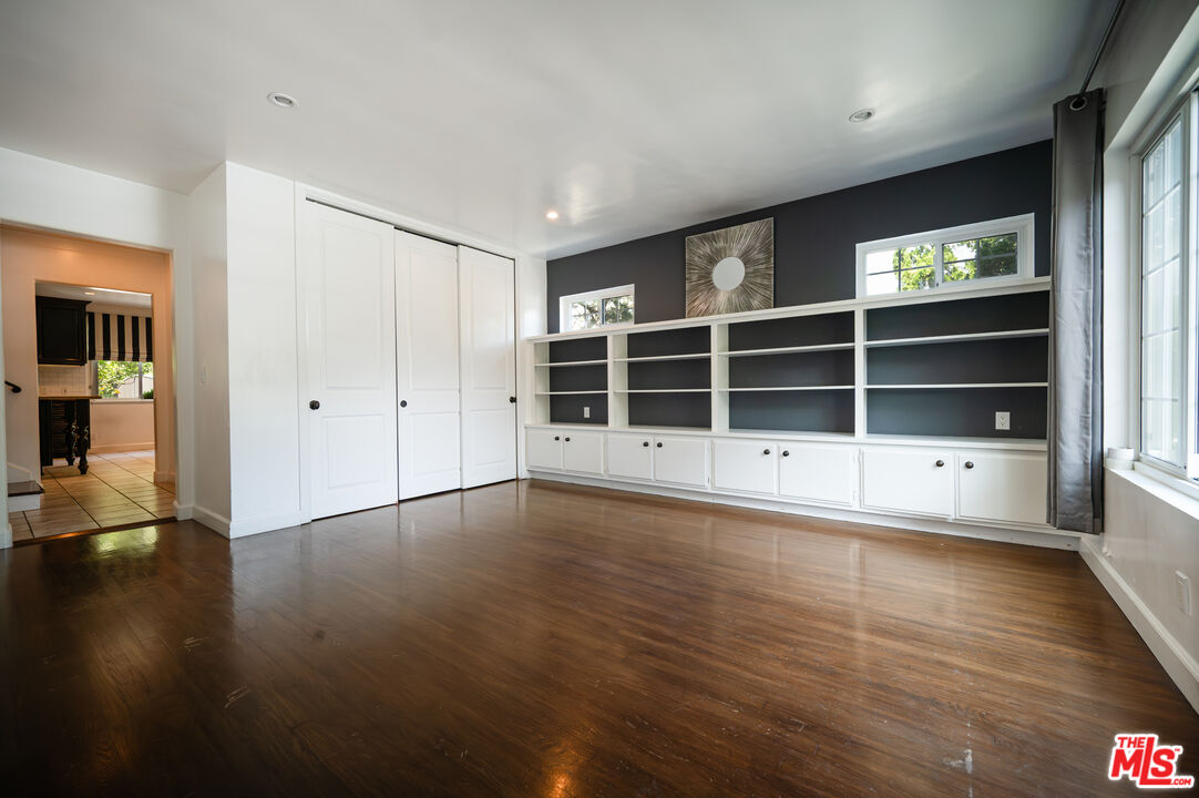503 North Greencraig Road Los Angeles, CA 90049 - Photo 5 of 59 an empty room with wooden floor and windows