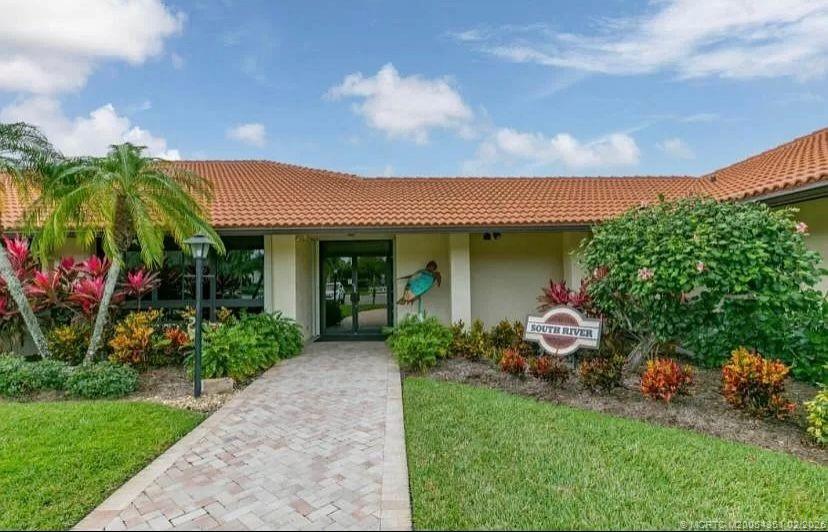 330 Southwest South River Drive, Unit 201 Stuart, FL 34997 - Photo 15 of 37 a front view of a house with a garden