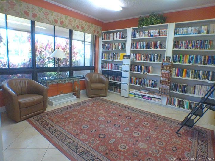 330 Southwest South River Drive, Unit 201 Stuart, FL 34997 - Photo 23 of 37 a living room with furniture and a book shelf