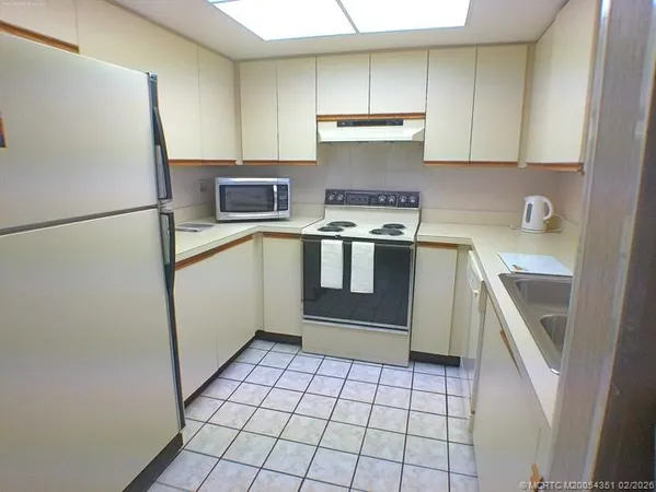 a kitchen with a stove a refrigerator and a sink
