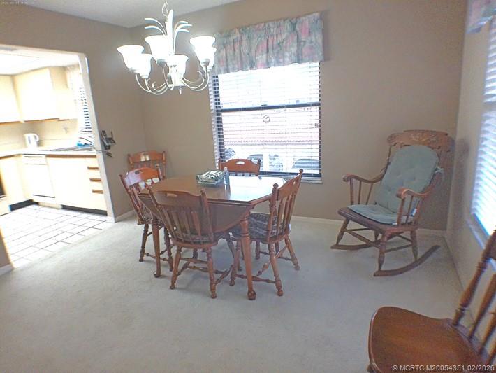 330 Southwest South River Drive, Unit 201 Stuart, FL 34997 - Photo 5 of 37 a view of a dining room with furniture a chandelier and a window