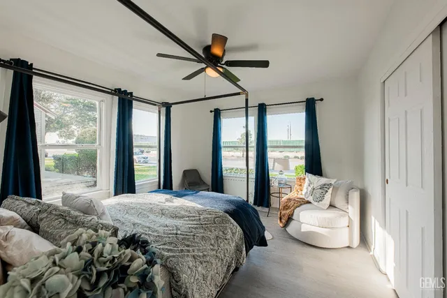 a bedroom with a bed a mirror and a potted plant