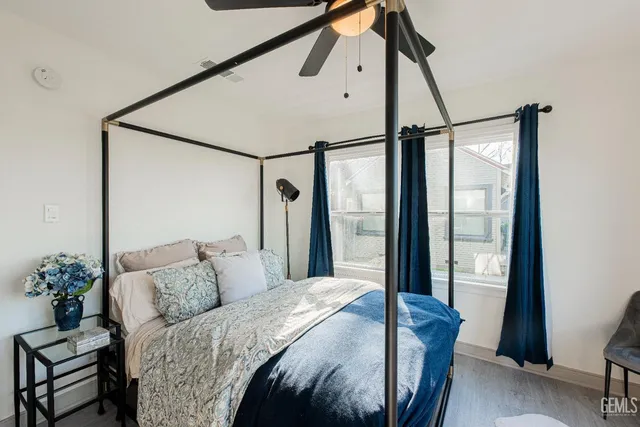 a bedroom with a large bed and wooden floor