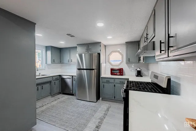 a kitchen with stainless steel appliances granite countertop a refrigerator and a sink