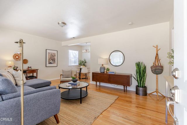 a living room with furniture a rug and a window