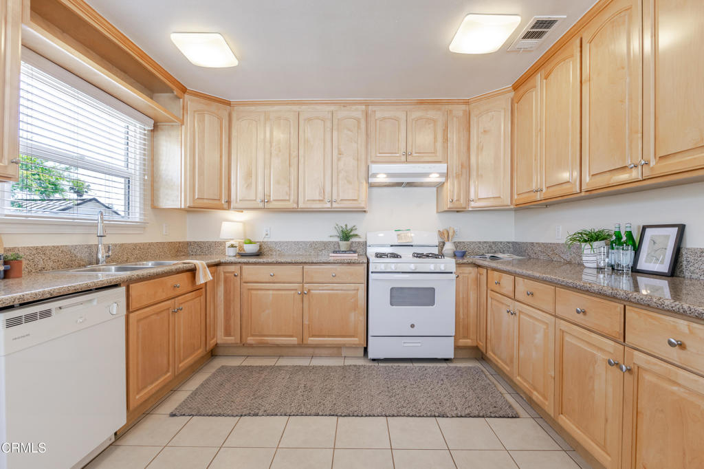 1500 East Topeka Street Pasadena, CA 91104 - Photo 9 of 20 a kitchen with granite countertop white cabinets white stainless steel appliances with a sink and dishwasher