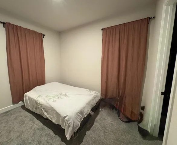 a spacious bedroom with a bed and a window