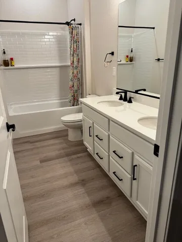a bathroom with a double vanity sink toilet and shower
