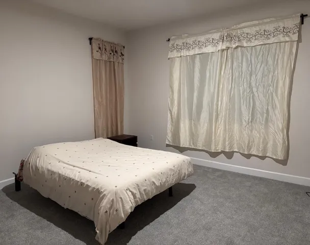 a bedroom with a bed and a curtain