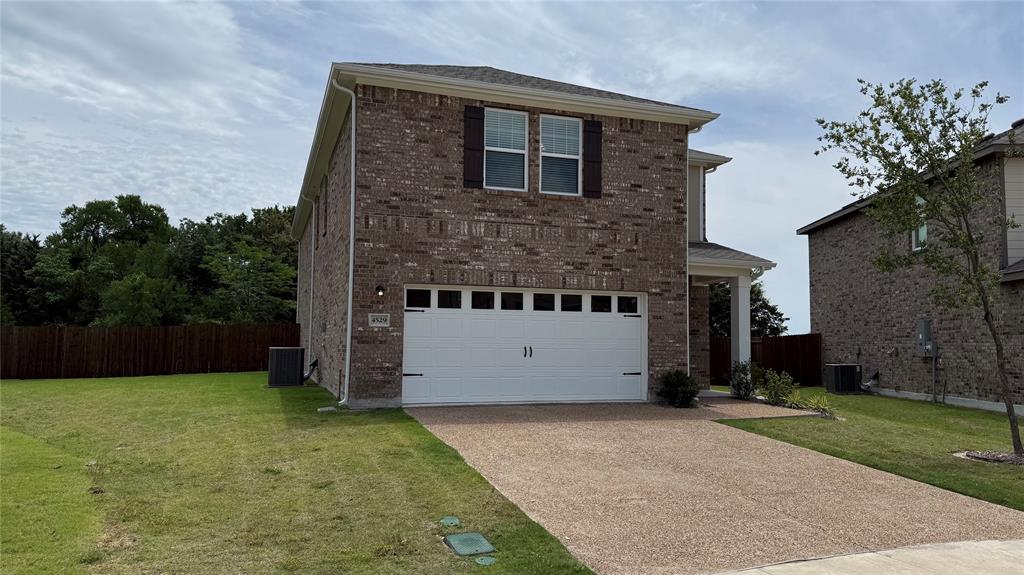 4529 Winecup Road Melissa, TX 75454 - Photo 2 of 29 Two-story brick exterior featuring a two-car garage, shuttered windows, a covered entry, and a paved driveway