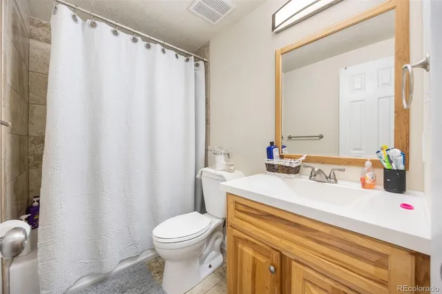 a bathroom with a sink a toilet and shower curtain