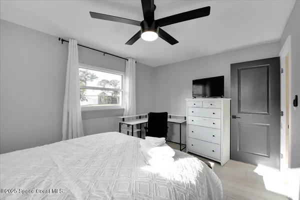 a bedroom with a bed and a chandelier